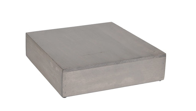 A plain, rectangular metal block with a smooth, matte finish is displayed on a white background, reminiscent of an Aspen Riser. The block sits flat with visible edges and slight shadows, suggesting a solid and heavy appearance.