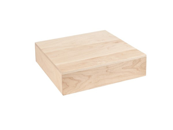 A blonde square riser with visible wood grain sits on a white background. The box has a simple, smooth surface and sharp edges, giving this display riser a modern, minimalist appearance.