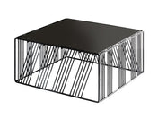 A modern, square coffee table with a solid black top and sides made of thin, evenly spaced diagonal black metal rods forms an open, geometric Portland Riser frame. The design creates a minimalist and airy appearance.