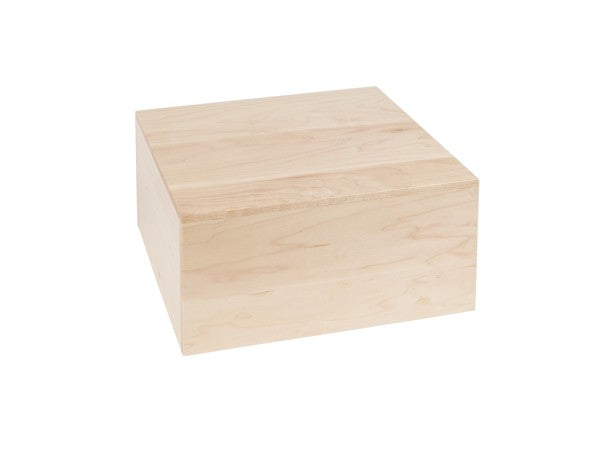 A plain, light-colored wooden Cal-Mil blonde square riser sits on a white background. The 12 x 12 riser features smooth surfaces, sharp edges, and a flush lid that highlights the natural wood grain pattern.
