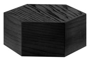 A solid black hexagonal Cinderwood Riser with a wood grain texture visible on its surfaces. The block is shown from a slightly angled perspective, emphasizing its geometric shape and matte finish against a plain white background.