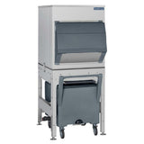 A commercial ice machine with a stainless steel body and a large, dark gray dispensing bin featuring a universal bin adapter. Set on a metal stand with a wheeled gray cart for collecting ice, it boasts generous ice storage capacity and a modern, industrial design.