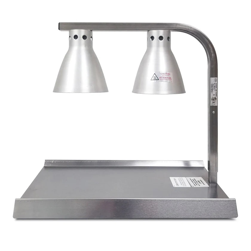A stainless steel Warma-Serve Food Warmer features two cone-shaped silver heat lamps on a curved bar above a rectangular warming tray, designed to keep food warm in commercial kitchens or buffets. Labels and warning stickers are visible on the lamp and tray.