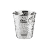 A shiny, stainless steel bucket with a hammered texture, horizontal engraved lines, and a round metal ring handle attached to one side. The TableCraft ice bucket is empty and stands on a white background.