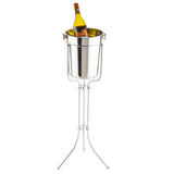 A chrome plated Wine bucket stand by TableCraft, featuring three slender legs and a bucket with side handles, holds a chilled bottle of white wine upright. The yellow label and cap are visible above the rim for easy identification.