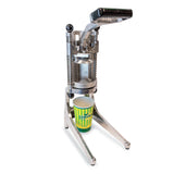 A manual aluminum lemon squeezer stands upright with its lever arm raised. Beneath the press, a striped yellow and green Lemonade cup waits to catch fresh juice. The sturdy, industrial design sits on a white surface.