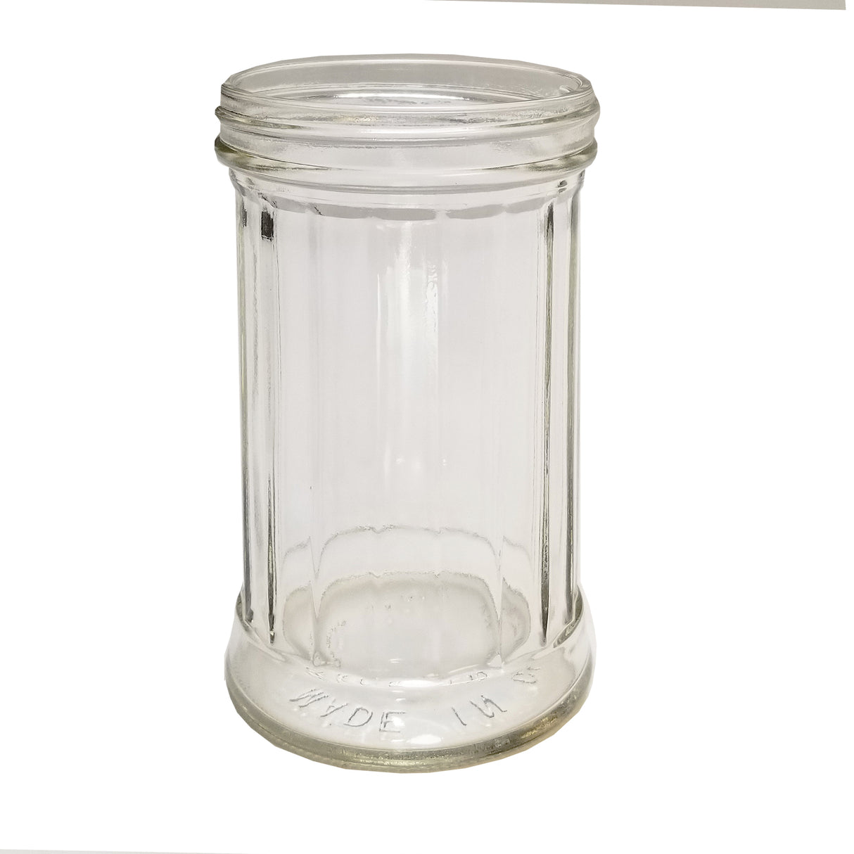 A clear, empty 12 oz fluted glass jar with vertical ridges, wide mouth, and thick base. The words MADE IN are embossed near the bottom rim. The TableCraft Products jar is photographed against a white background.