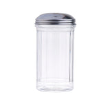 A clear, fluted glass sugar dispenser with vertical ridges and a shiny stainless steel lid featuring a small slot for pouring. The background is plain white.