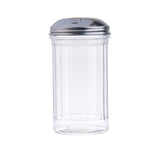 A clear, fluted glass sugar dispenser with vertical ridges and a shiny, stainless steel pourer lid featuring a small flap for pouring. The dishwasher safe dispenser stands upright against a plain white background.