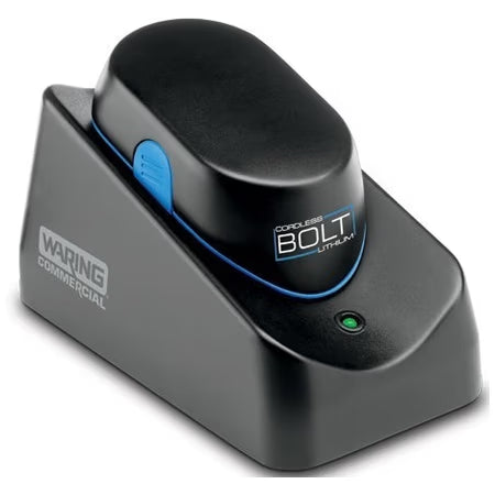 A black Waring Commercial BOLT Cordless Blender sits on its matching charging base with a green indicator light and Waring logo. The device, designed as an immersion blender, features a blue accent and a blue button on its side.
