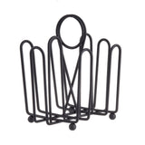 A black powder coated metal wire napkin holder with a geometric, open-frame design. Four arched sides surround a rectangular base, while a merchandising ring at the top adds a modern, minimalist touch. The holder stands on four small round feet.