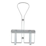 A chrome plated TableCraft wall-mounted shower rack with a rectangular basket, two supporting vertical bars, a top handle for hanging, and two screw holes for mounting. The rack is empty and displayed against a white background.