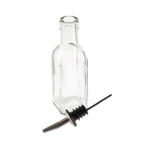 A clear, empty 6 oz. glass bottle stands upright next to a stainless steel pourer with a rubber stopper, both on a white background. The bottle has no label and features a narrow neck, while the pourer is placed in front of it—ideal for Oil & Vinegar Bottles.