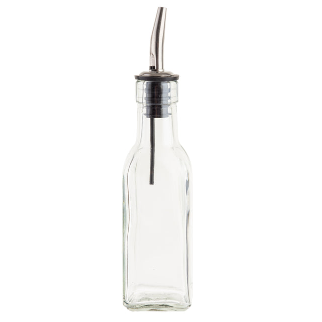 A clear, empty glass Oil & Vinegar Bottle with a square base and narrow neck, topped with a stainless steel pourer and black rubber stopper. The spout has a curved nozzle for controlled pouring, like the TableCraft 60125 used in kitchens and restaurants.