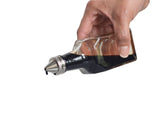 A hand tilts an 8 oz glass bottle Oil & Vinegar Dispenser with a metal spout, pouring a dark liquid, likely soy sauce, against a white background. A droplet hangs at the tip of the spout, about to fall.