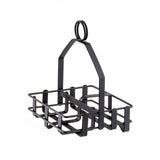 A black powder coated metal basket with a rectangular base and open grid sides, featuring sturdy vertical supports and a looped handle on top. This minimal condiment rack is ideal for holding salt and pepper shakers or organizing small items.