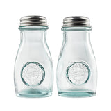 Two empty, clear recycled glass jars with stainless steel tops are side by side. Each shaker has a round embossed logo on the front reading Authentic Recycled Glass. The background is plain white, and the shakers are clean and unused.
