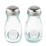 Two empty, clear recycled glass jars with round bodies and stainless steel tops stand side by side on a white background. Each shaker has an embossed circular logo on the front, making this shaker set both stylish and eco-friendly.