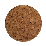 A round, flat cork coaster by TableCraft Products is viewed from above. The natural, rough texture features irregular light brown and tan cork pieces, small holes, and an uneven pattern. A white background highlights its circular shape and earthy appearance.