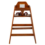 A stackable wooden high chair viewed from the front, with an angled backrest, three horizontal footrests, a dark wood finish, a safety warning label at the top, and a maroon safety strap. The chair has a simple, classic design.