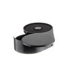 A round, black plastic case with a hinged lid is open to reveal a foam-lined interior and a small, round CR2032 battery inside. The smooth, glossy surface glows under the light, resembling sleek rimmer containers with swing-out trays for easy access.