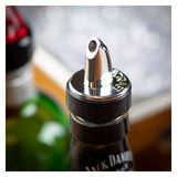 Close-up of a chrome plated Free Flow Pourer on a Jack Daniel’s bottle. The shiny, BPA free spout is centered in the frame, with softly blurred bottles and a bright, bokeh background adding depth.