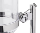 Close-up of a transparent polycarbonate cereal dispenser with a silver metal frame, spigot handle, and knurled knob on top. The container is partially filled, dishwasher safe, and mounted on a shiny metal stand.