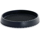 A round, shallow black rubber drip tray with a raised, textured surface of evenly spaced bumps. The smooth outer edge is slightly angled, while the bottom features a jagged, saw-like pattern for grip. The mat sits on a white background.