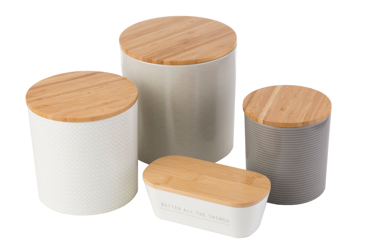 Four minimal, modern canisters with bamboo lids are grouped together. Three upright melamine canisters in white, light gray, and dark gray stand beside a rounded rectangular white container labeled “BUTTER ALL THE THINGS.”.