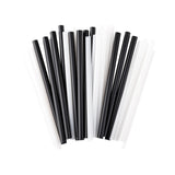 A group of alternating black straws and white plastic drinking straws is arranged vertically and fanned out on a white background. The straw ends are visible and closely packed together, creating a striking striped pattern.