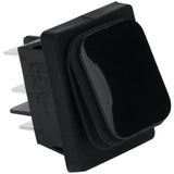 A close-up of a black rectangular rock switch with a slightly raised, rounded top and multiple metal prongs for electrical connections on the side. The switch is made of plastic and is designed for panel mounting in Empura Equipment.