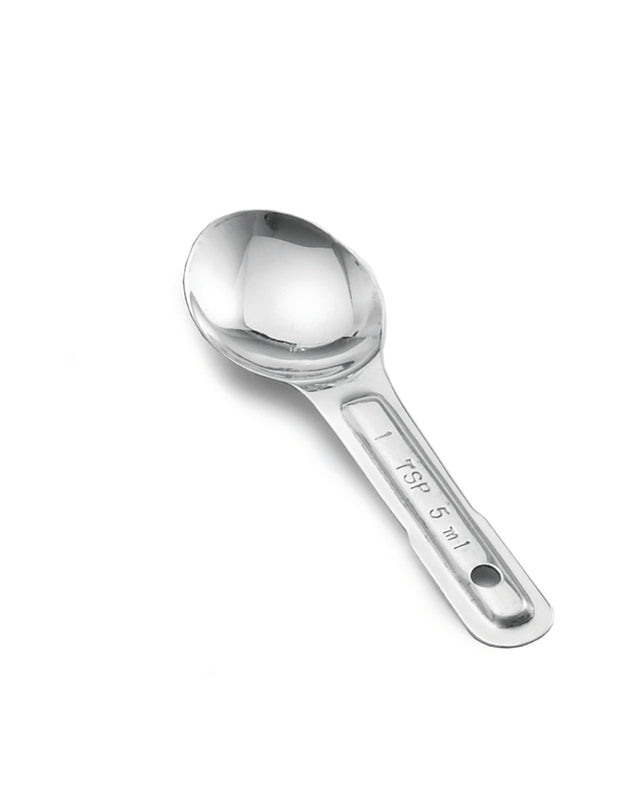 A single stainless steel measuring spoon is shown on a white background. The handle is flat with a hole at the end and engraved with “1 TBS / 15 ml.” The spoon has a round, polished bowl and a shiny, reflective surface.