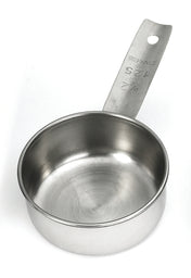 A stainless steel measuring cup with a flat handle is shown. The handle, marked “1/2 CUP, 125 mL, STAINLESS,” highlights its dishwasher safe design. The clean, empty cup is displayed from overhead on a plain white background.