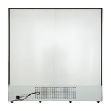 A large, rectangular white commercial refrigeration appliance features a metal panel with ventilation holes at the bottom. A black electrical cord is plugged into the lower left side, while the surface above remains plain and smooth.