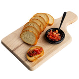A TableCraft bread board with a natural finish wood holds six slices of toasted bread. Beside them, a small black bowl filled with diced tomato bruschetta and a spoon sits on the white background; one slice is topped with the fresh mixture.