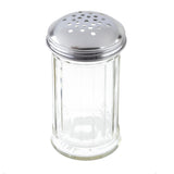 A clear, fluted glass shaker with vertical grooves and a round stainless steel lid featuring multiple holes, typically used for dispensing salt, pepper, or other seasonings. The image is taken against a white background.