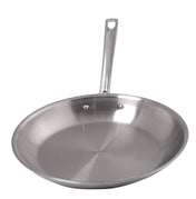A shiny, stainless steel fry pan with an aluminum core features a long handle and a small hole at the end. Its smooth, slightly curved interior and flat base are securely fastened by two rivets. The background is plain white.