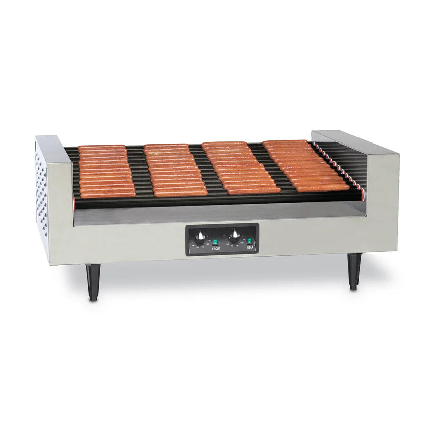 A stainless steel hot dog grill with multiple rows of evenly spaced, rotating rollers, cooking about 18 hot dogs. Featuring a slanted hot dog grill design, it has two control knobs, indicator lights on its front panel, and stands on four black legs.