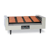 A stainless steel hot dog grill with multiple rows of evenly spaced, rotating rollers, cooking about 18 hot dogs. Featuring a slanted hot dog grill design, it has two control knobs, indicator lights on its front panel, and stands on four black legs.