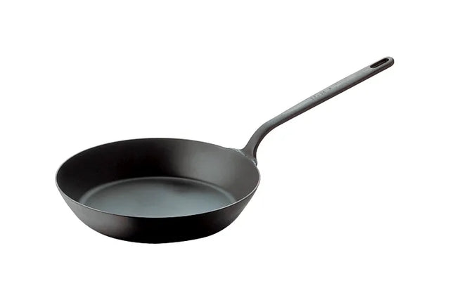 A black carbon steel fry pan with a smooth, round base and flared sides. It has a long, straight handle with a hole for hanging. Made of metal, this pan is suitable for induction cooking and is photographed on a white background.