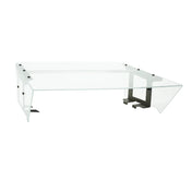 A modern, transparent glass desk with a wide rectangular surface features a unique angular design, resembling the sleek lines of an NSF food shield. Black metal brackets and supports provide stability, creating an airy, minimalist appearance.