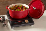 A red Ironlite Casserole filled with cooked food sits on a black induction cooktop with digital controls, displaying 488 in red numbers. The casserole lid rests nearby on the white countertop, and a metal kitchen utensil is visible to the left.