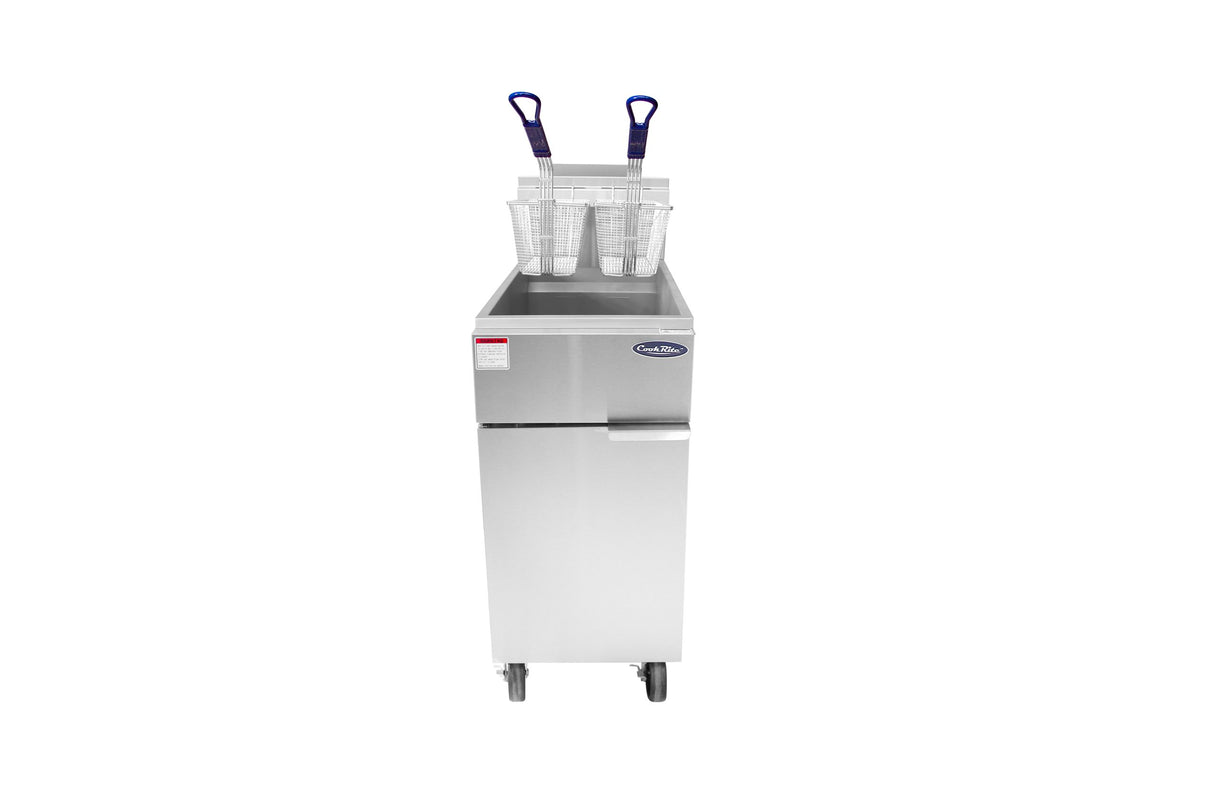 A tall, stainless steel commercial deep fryer with 50 lb. capacity stands on wheels. On top, two metal baskets with blue handles rest inside the fryer beside two clear plastic measuring cups. The LP gas unit features a handle and label on the front.