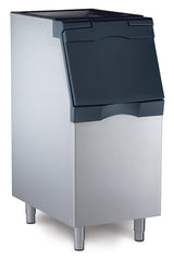 A stainless steel NSF ice bin with a black, slanted, flip-up lid stands on four metal legs. Its rectangular, sturdy design is ideal for commercial use in restaurants or bars and pairs perfectly with a top-mounted ice maker.