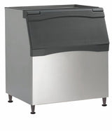 A commercial Ice Bin with a stainless steel body and black plastic flip-up lid, featuring polyurethane insulation for optimal cooling. The bin stands on four short legs, has a slightly angled front, and boasts a clean, industrial appearance.
