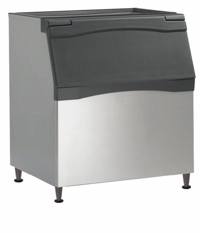 A commercial Ice Bin with a stainless steel body and black plastic flip-up lid, featuring polyurethane insulation for optimal cooling. The bin stands on four short legs, has a slightly angled front, and boasts a clean, industrial appearance.