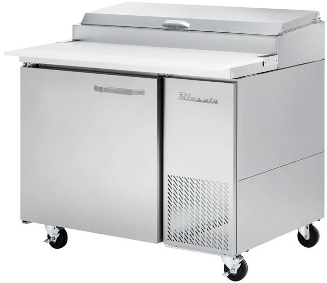 A commercial refrigerated stainless steel pizza prep table with a flat white work surface, hinged lid, single door with handle, ventilation grilles, and four caster wheels. The True brand is visible on the front door.