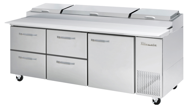 A large stainless steel refrigerated prep table with six handles: four drawers on the left, a door on the right, and three covered compartments on top. The unit stands on four caster wheels and features a vent with the brand name True.