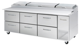 A large stainless steel Pizza Prep Table on wheels with six drawers, a right-side cooling compartment, and three top-opening lids. The surface serves as a prep counter, and the unit features a True brand logo on the right.
