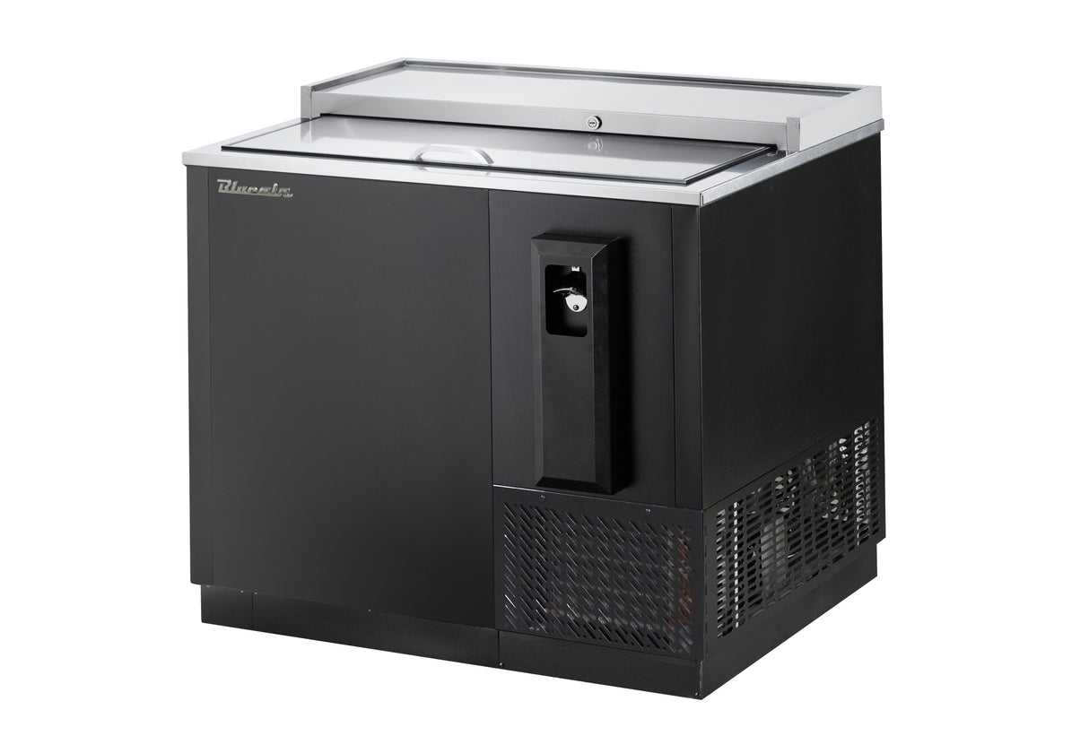 A commercial bottle cooler with a stainless steel top, side-mounted refrigeration, a sliding glass lid, built-in bottle opener, and vented section at the bottom right. The unit sits on a solid base for efficient beverage storage and chilling.